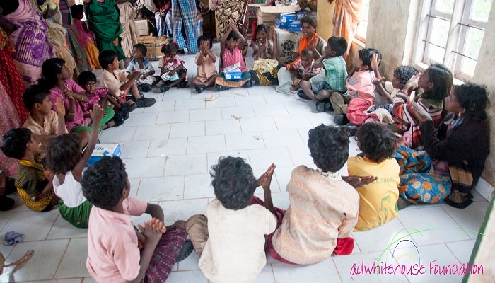 Children seated in a circle during a village activity