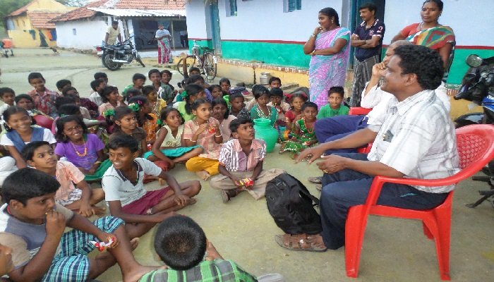 Children and villagers gathered for a community session
